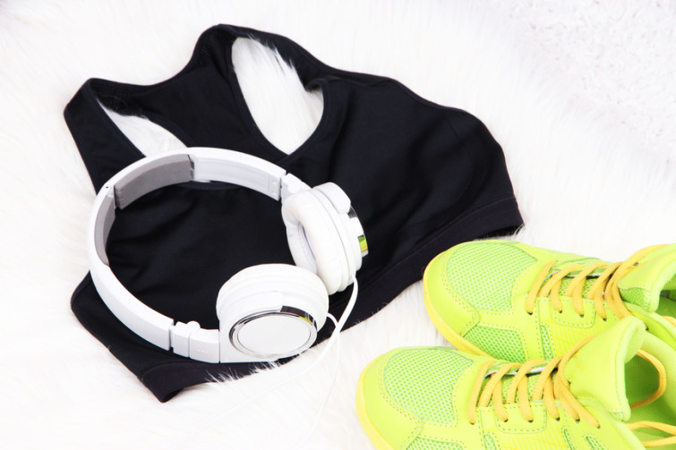 Sport clothes, shoes and headphones on white carpet background.